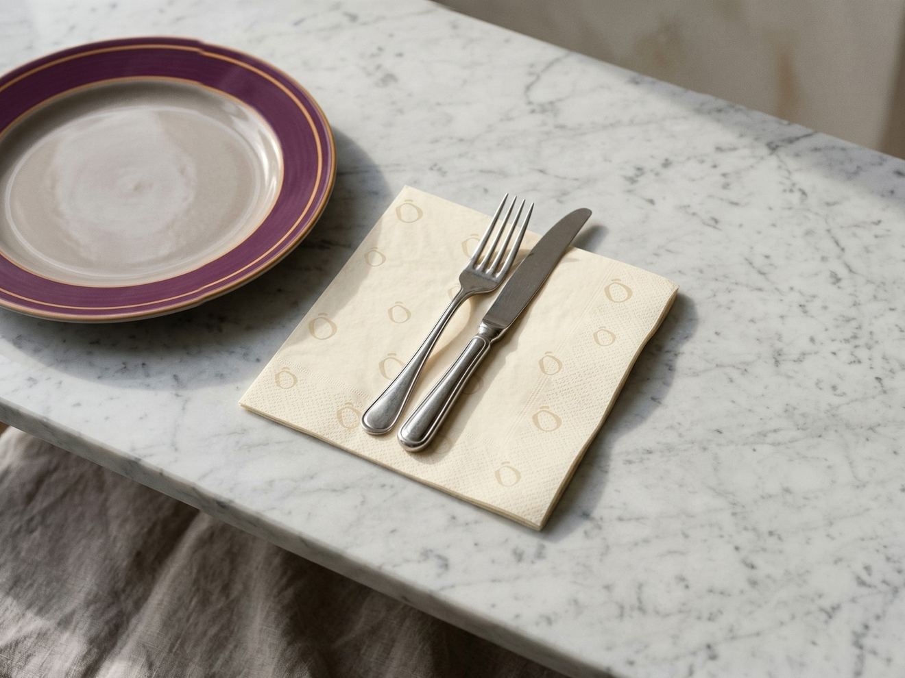 A cream Lento napkin under a knife and fork