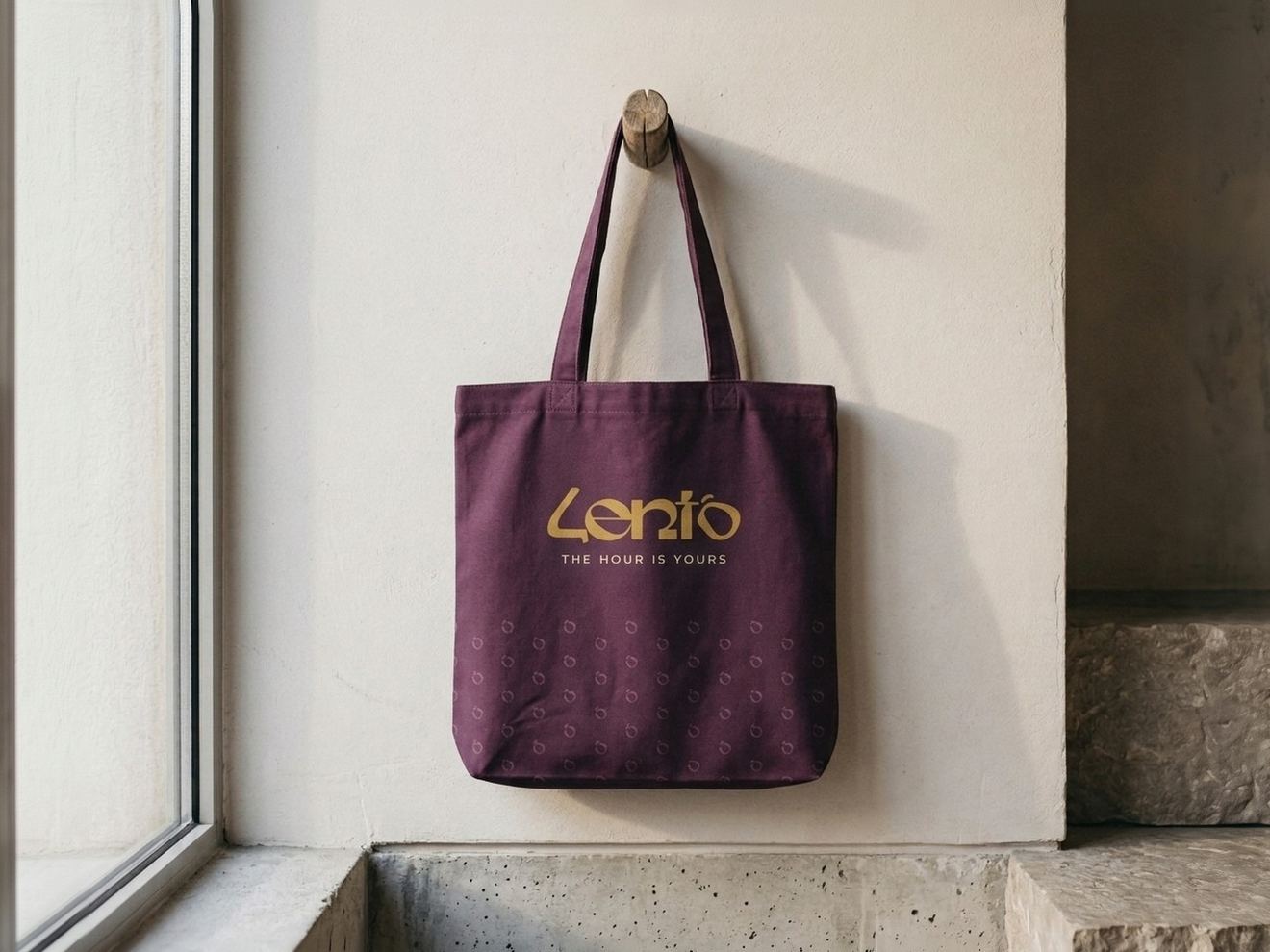 The plum Lento tote bag hanging on a wooden peg