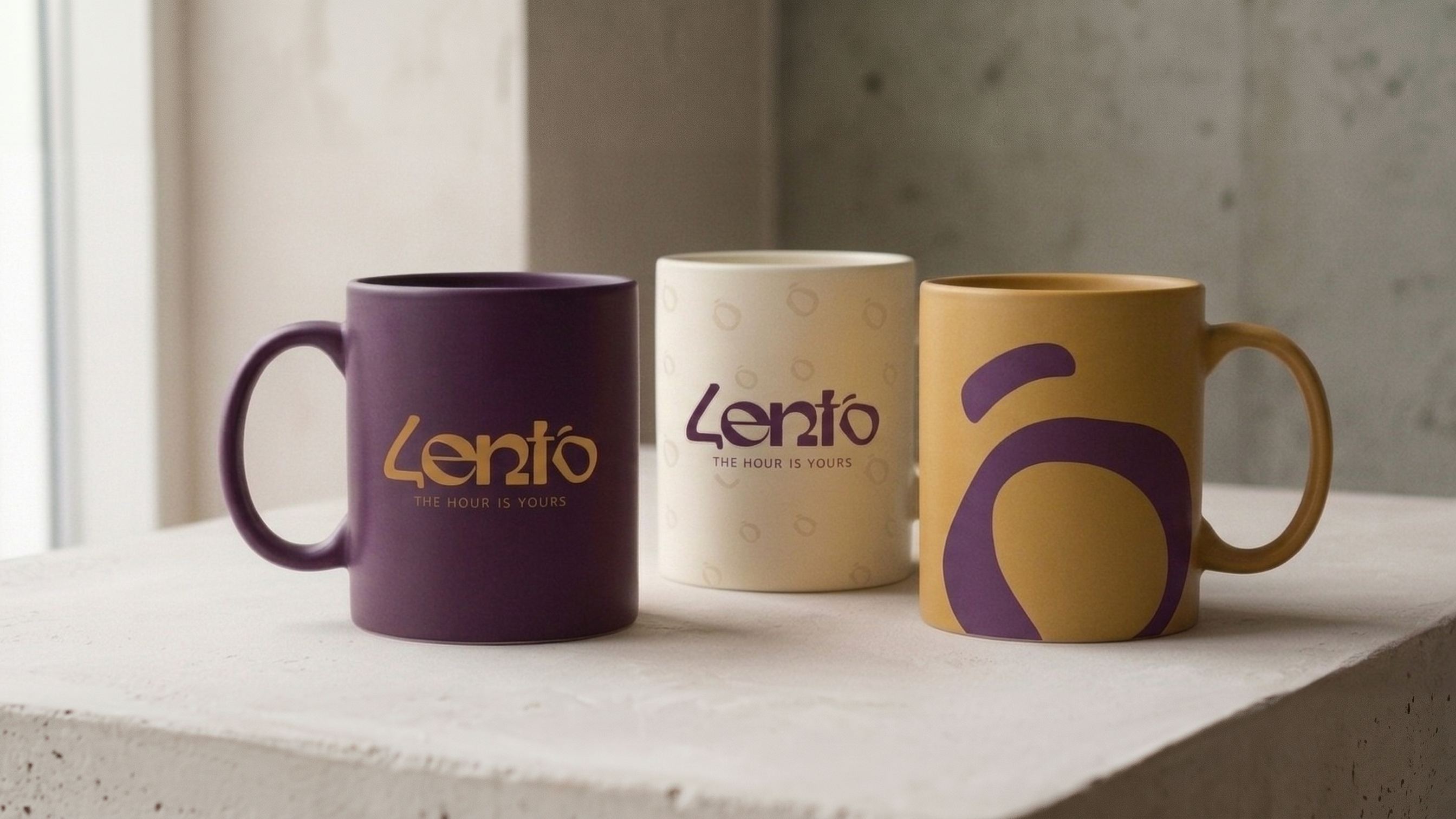 Three Lento mugs, aubergine, cream and mustard, on a plaster ledge