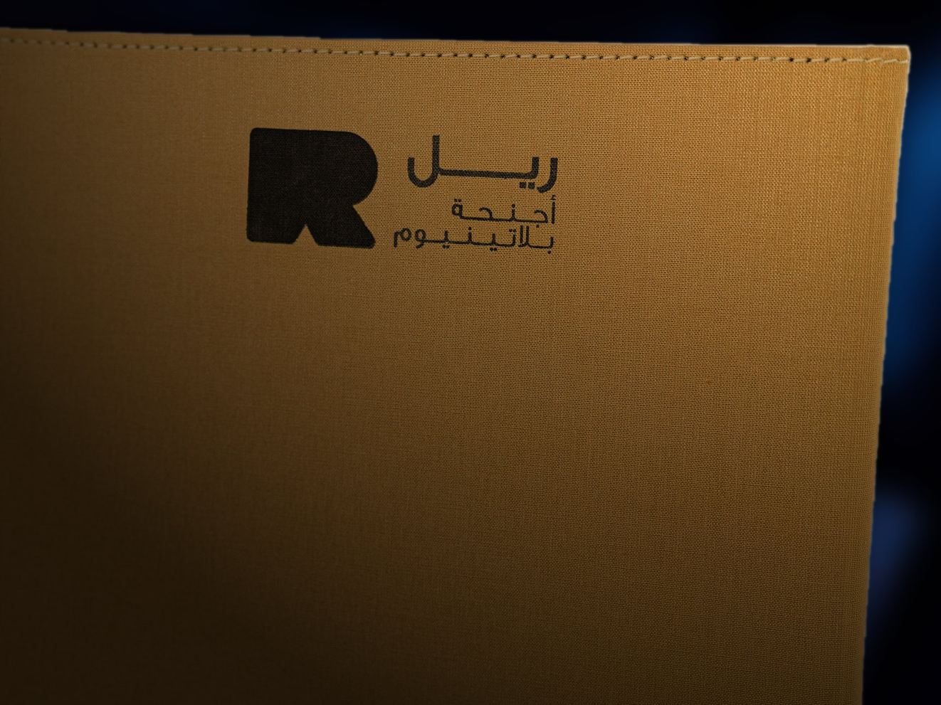The gold linen cover with the R and the Arabic name of the Platinum Suites, in warm low light