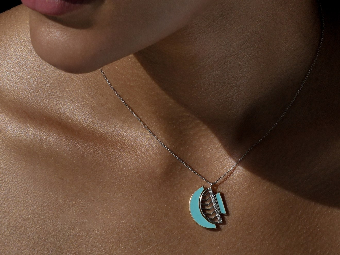 The Amara pendant in turquoise enamel with a diamond bar, at the collarbone